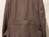 an image of a man wearing a brown jacket and jeans