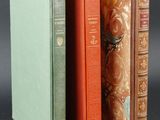 trois livres sont empilés sur une table
