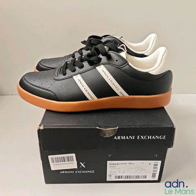 a close up of a pair of black and white sneakers on top of a box