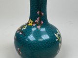 a blue vase with flowers on it sitting on a table