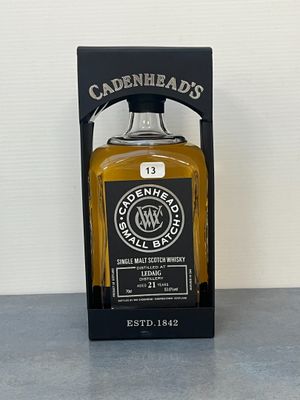 une bouteille de whisky posée sur une table à côté d'une boîte