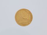 a close up of a gold coin on a white surface
