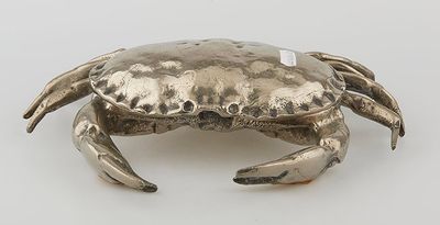an image of a silver crab sitting on top of a white surface