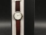 un gros plan d'une montre dans un coffret posé sur une surface noire