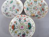 three chinese porcelain plates with floral designs on them on a table
