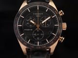 a close up of a watch on a black surface