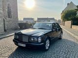 une photo d'une voiture noire garée dans une rue pavée