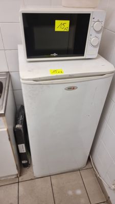 un micro-ondes posé sur un réfrigérateur dans une cuisine