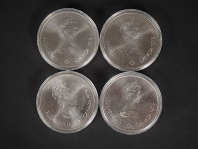 quatre pièces d'argent sont empilées les unes sur les autres sur une surface noire