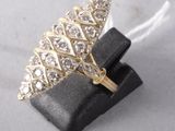an image of a gold and diamond ring sitting on top of a black ring holder