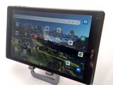 someone is holding a tablet with a picture of a mountain in the background