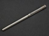a silver pen sitting on top of a black surface