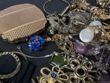a pile of jewelry on a table with a purse