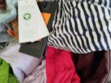 a cat that is sitting in a suitcase full of clothes