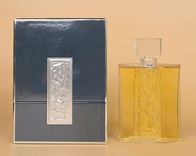 l'image d'un flacon de parfum posé à côté d'une boîte