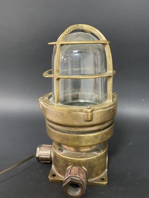 une lampe en laiton plaqué, surmontée d'un dôme en verre