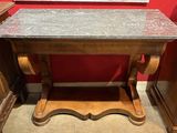 une petite table avec un plateau en marbre dans une pièce