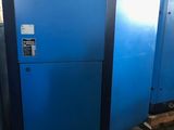 a couple of blue refrigerators sitting next to each other in a warehouse