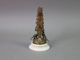a statue of a bird sitting on top of a marble base