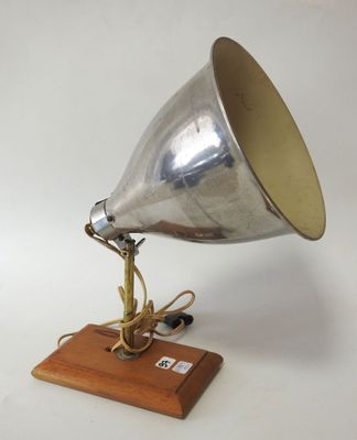 an old fashioned silver metal lamp on a wooden base