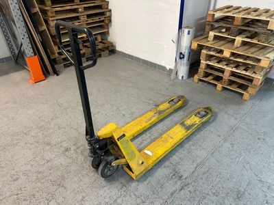 un chariot élévateur jaune avec des palettes en arrière-plan