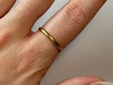 a woman ' s hand with a gold ring on it