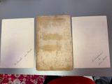 three papers are sitting on top of a table next to a red chair