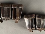 pair of antique silver plated belt buckles on a gray surface