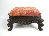 un petit repose-pieds surmonté d'un coussin