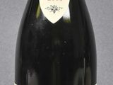 bottle of red wine sitting on a table with a gray background