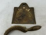 une plaque en laiton ancien munie d'une poignée sur laquelle est représentée une femme