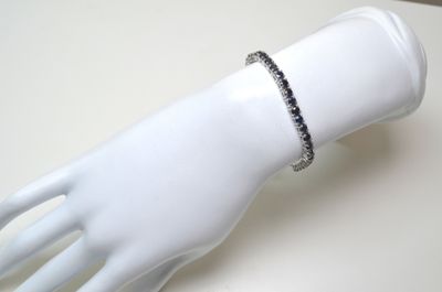 bracelet en diamants noirs et blancs sur la main d'un mannequin