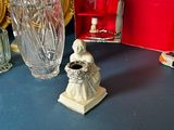a glass vase and a small figurine on a table