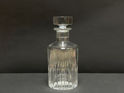 une photo d'une bouteille en verre transparent posée sur une table
