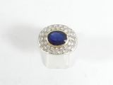 gros plan d'une bague avec une pierre bleue entourée de diamants