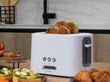 un grille-pain blanc posé sur une table en bois