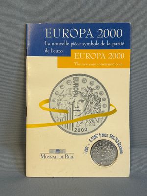 un livre sur lequel est posée une pièce de monnaie