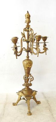 a brass candelab with three candles on it