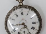 a silver pocket watch with roman numerals on it