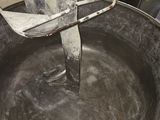 a large metal bowl with a mixer on top of it