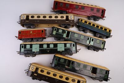 cinq petits trains miniatures posés sur une surface blanche, l'un posé sur l'autre