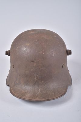 un vieux casque est posé sur une surface blanche, à côté d'une paire de ciseaux