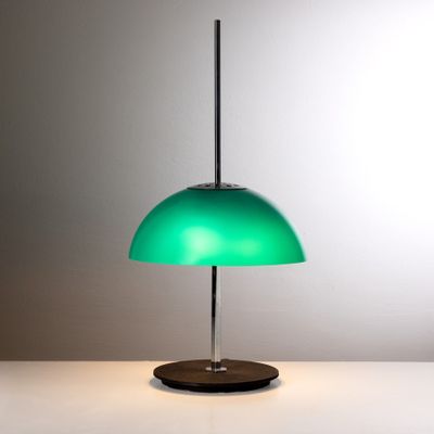 lampe de table verte posée sur une table blanche, sur fond gris