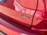 a close up of a red car with a sticker on it