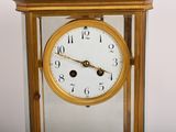 a gold clock with a white face and black hands