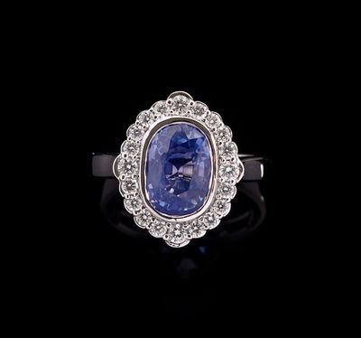 an oval blue sapphire and diamond ring on a black background