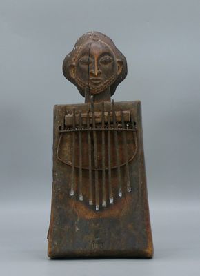 une sculpture en bois représentant une femme tenant un instrument de musique