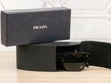 prada sunglasses in a black box on a wooden table