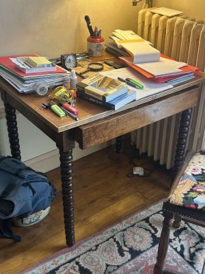 une petite table sur laquelle sont posés de nombreux livres, dans un coin de la pièce
