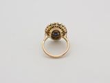 a close up of a gold ring with a blue stone